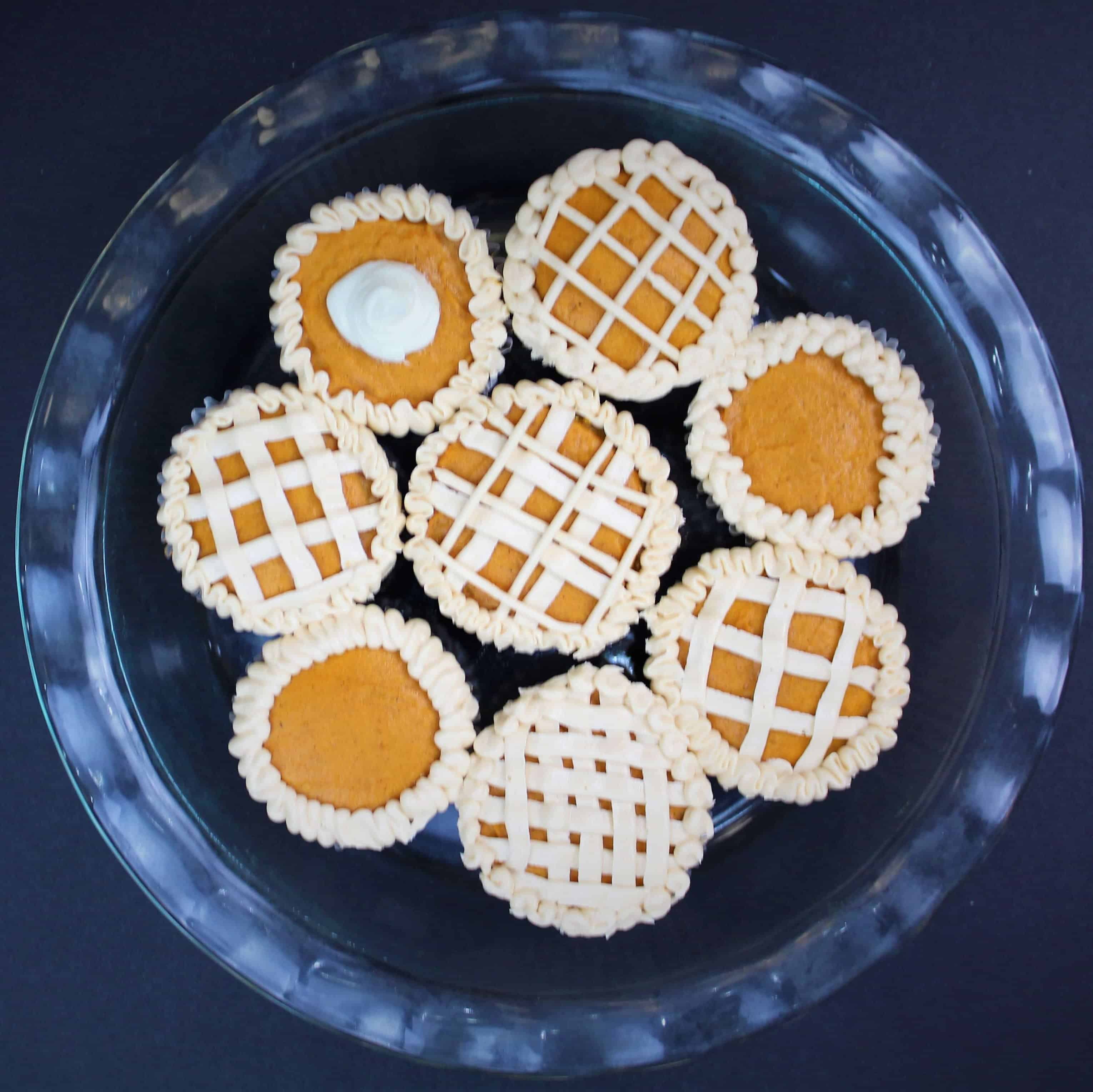 图为最可爱的南瓜馅饼杯形蛋糕,饰以奶油糖霜,看起来像馅饼皮