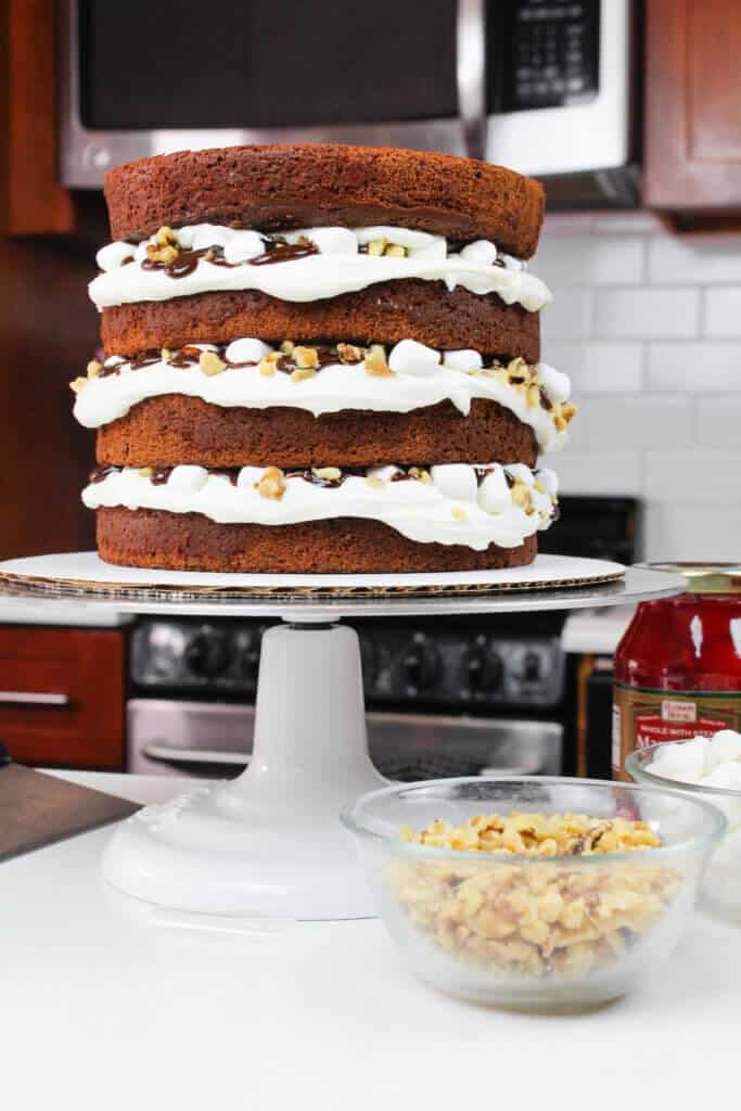 填充有奶油棉花糖，巧克力甘纳许，迷你棉花糖，和切碎的核桃堆叠巧克力蛋糕层