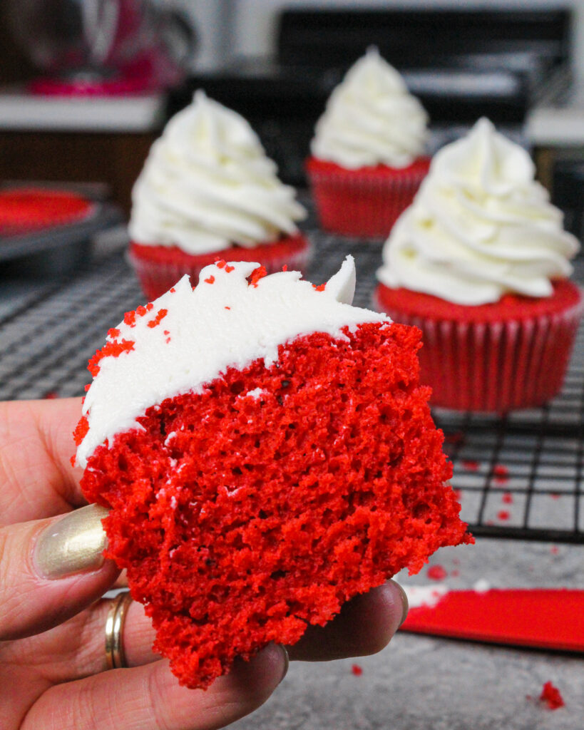 潮湿的红色天鹅绒蛋糕的图像，切成两半以显示潮湿的面包屑