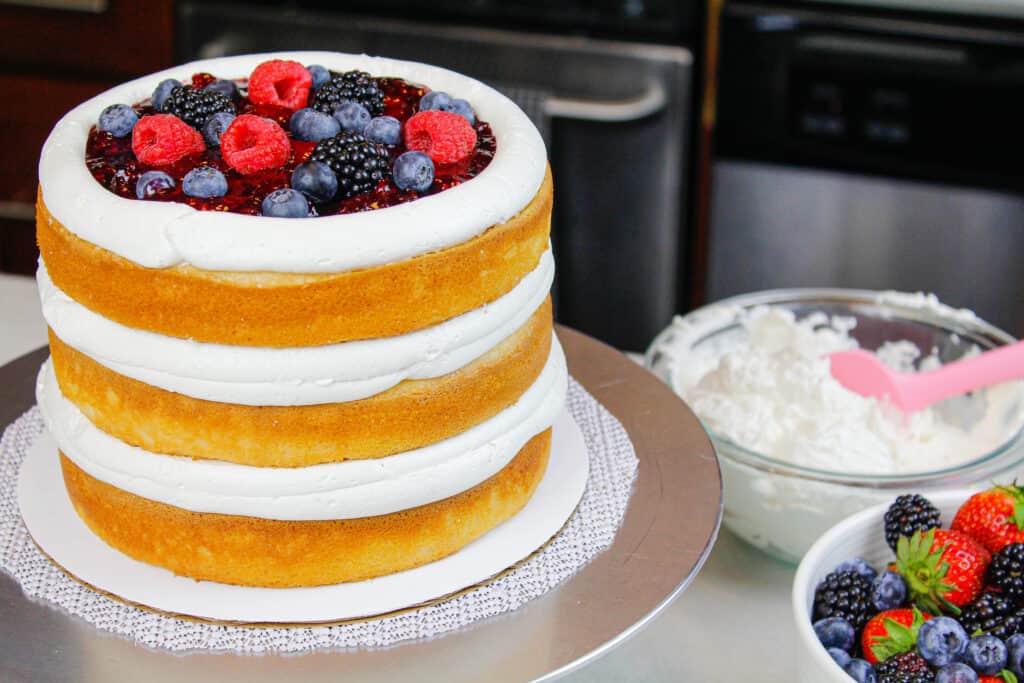 蛋糕层数的图象用混杂的莓果填装和睫毛膏乳脂干酪果冻和管道的结霜水坝堆积