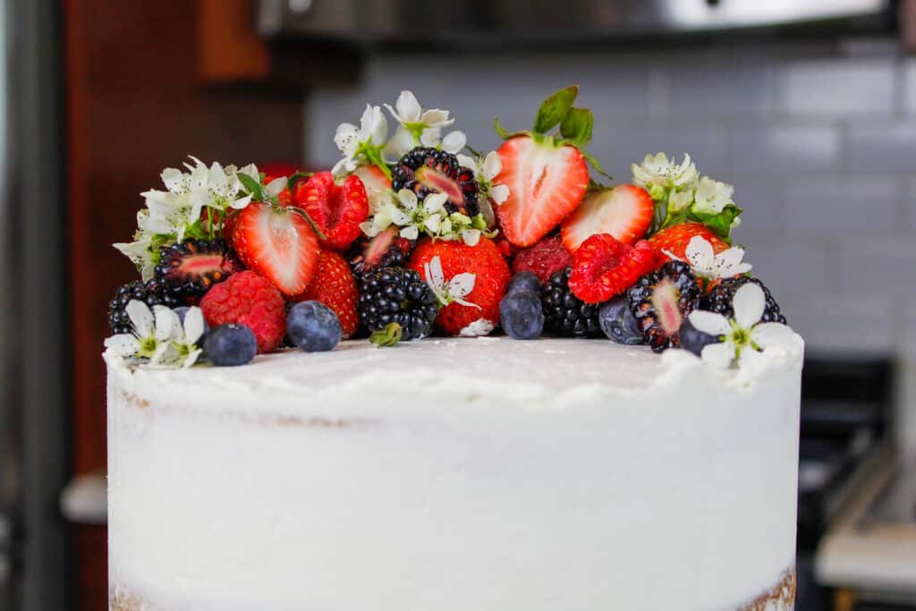 用新鲜的莓果和可食的花的蛋糕上面的图象春天和复活节的