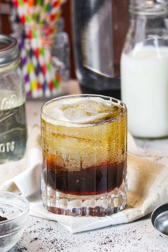 浓咖啡苏打水在一个漂亮杯子中，被用来制造的成分包围