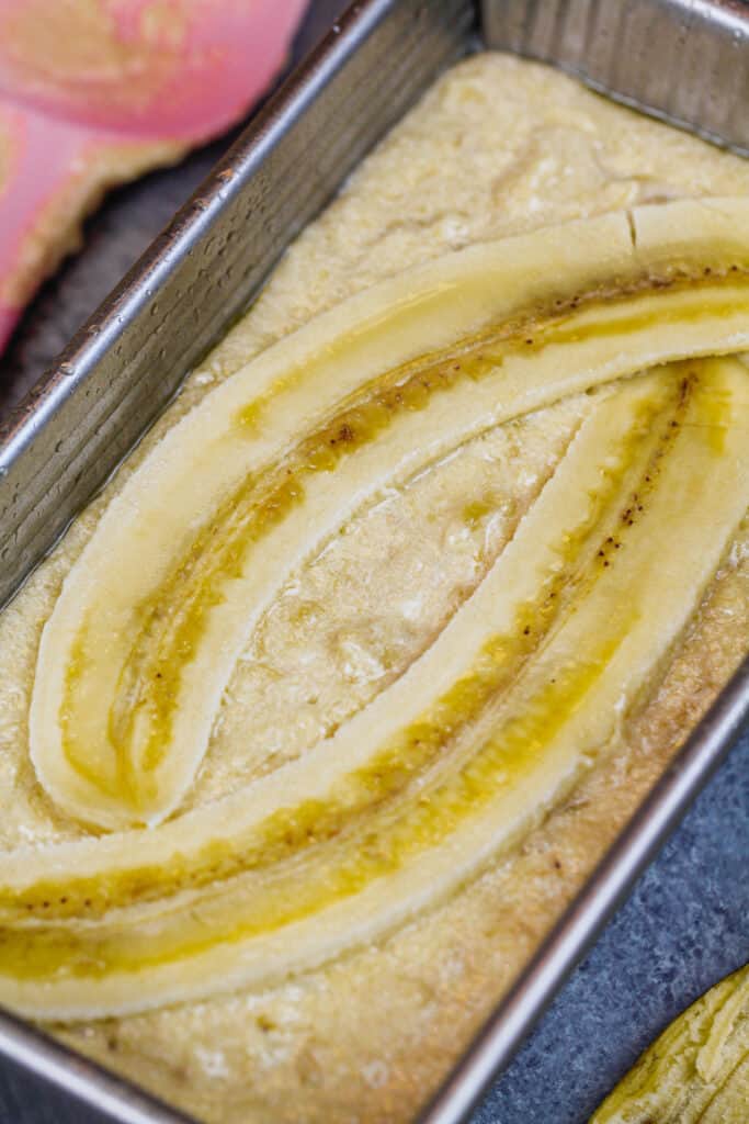 Banana面包面包的图像在大面包平底锅上搭配额外的糖和切片的香蕉，让它看起来很漂亮