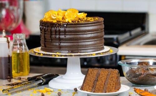 这张图片上的巧克力橙色蛋糕前面有一片，显示出蛋糕层的松软和柔嫩