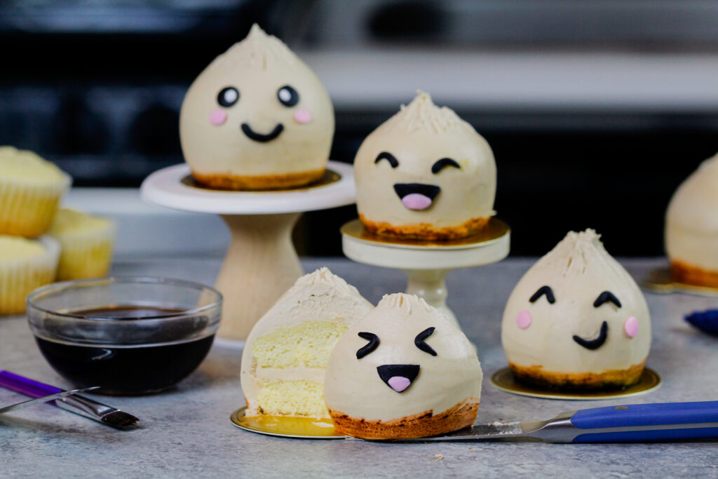 饺子杯形蛋糕的图像与一个切开，展示它的潮湿香草蛋糕