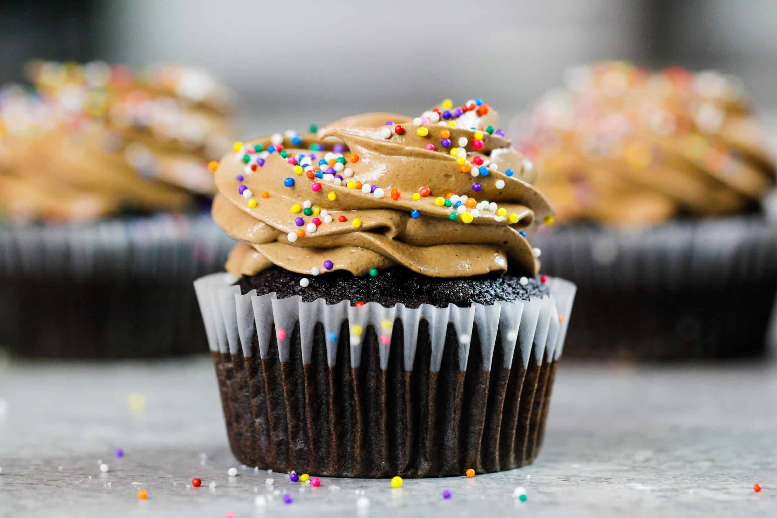 在巧克力纸杯蛋糕上撒上一层巧克力意大利蛋白霜奶油冻