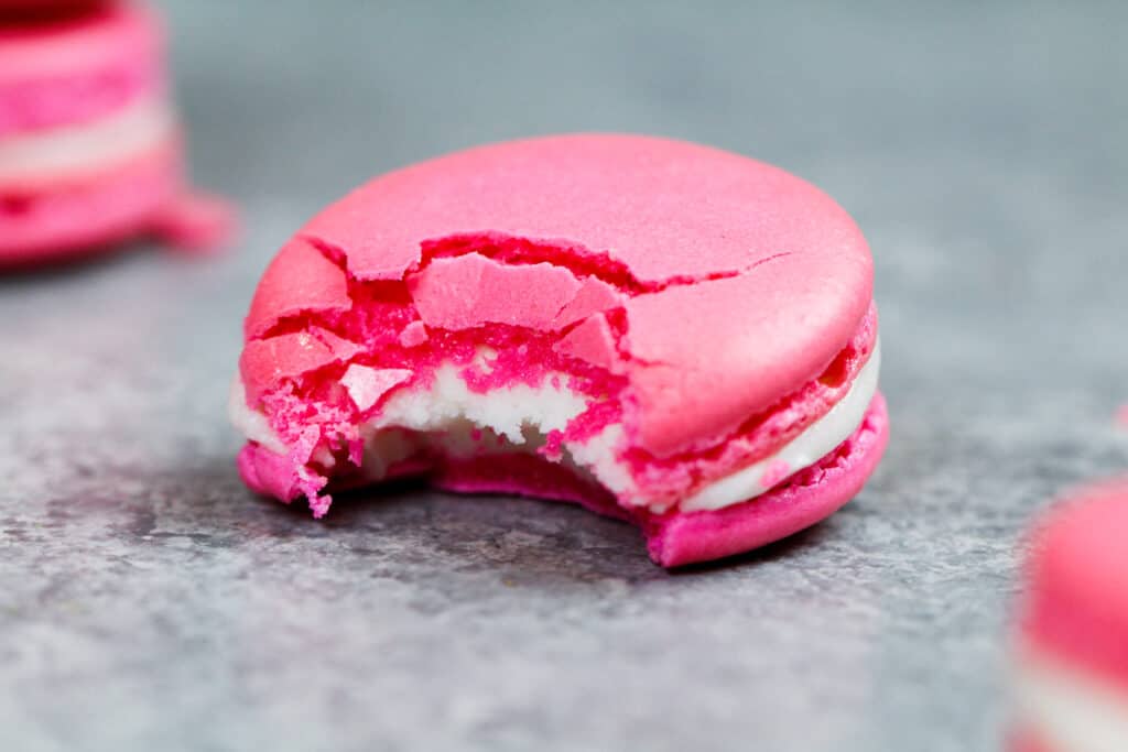 一只法国麦克饼的形象被咬入展示它的嚼心和酥脆壳