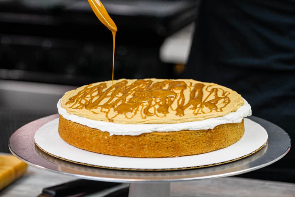 饼干黄油蛋糕正在组装，并在每个蛋糕层之间淋上饼干黄油