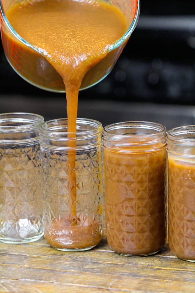 倒入梅森罐子的速溶罐苹果黄油的图象