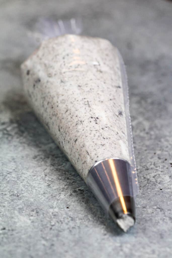 图像oreo buttercream糖霜放在管道袋里填充饼干和奶油奶油饼干