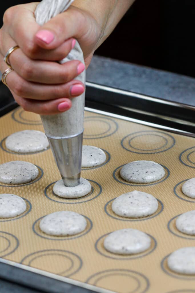 法国曲奇饼和奶油色饼干的图象被用管子被送到硅蛋白席子上