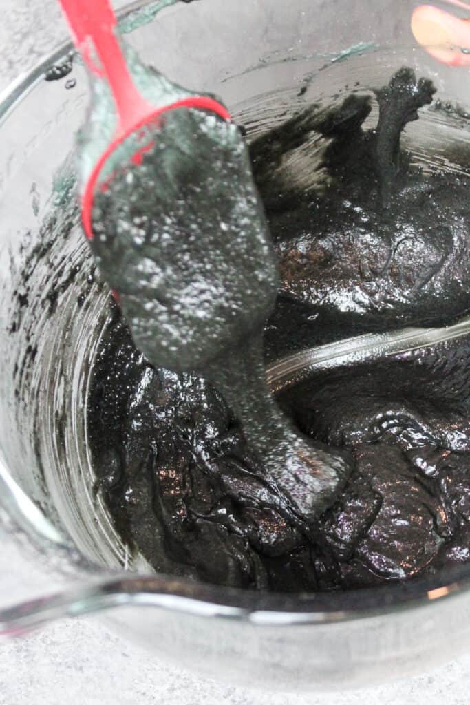 黑色马卡龙面糊的形象，一直混合到完美的一致性