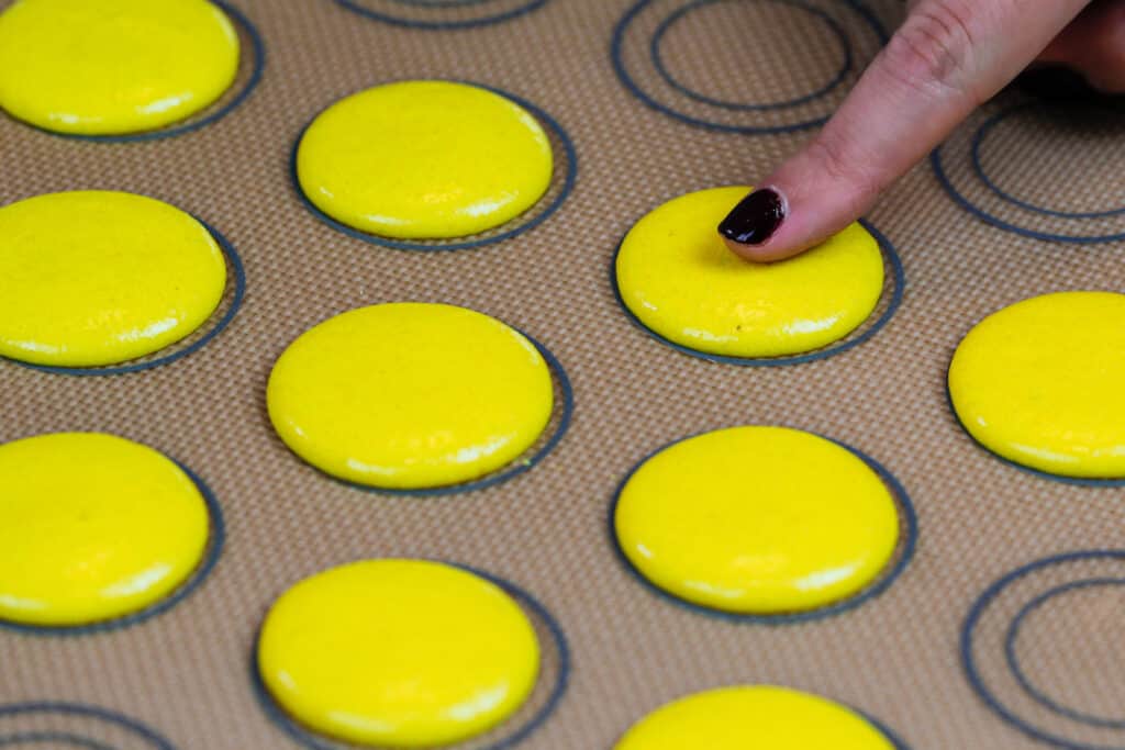 在被烘烤之前休息并且形成了可爱的皮肤的黄色macaron壳的图象