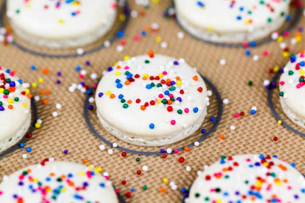 烤白马卡龙的外壳上撒着无与伦比的糖屑，做成彩虹马卡龙