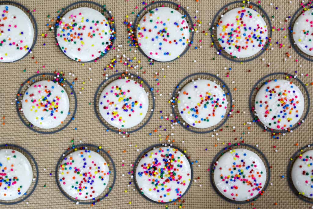 白色macaron壳的图象冠上与彩虹洒在被烘烤之前休息