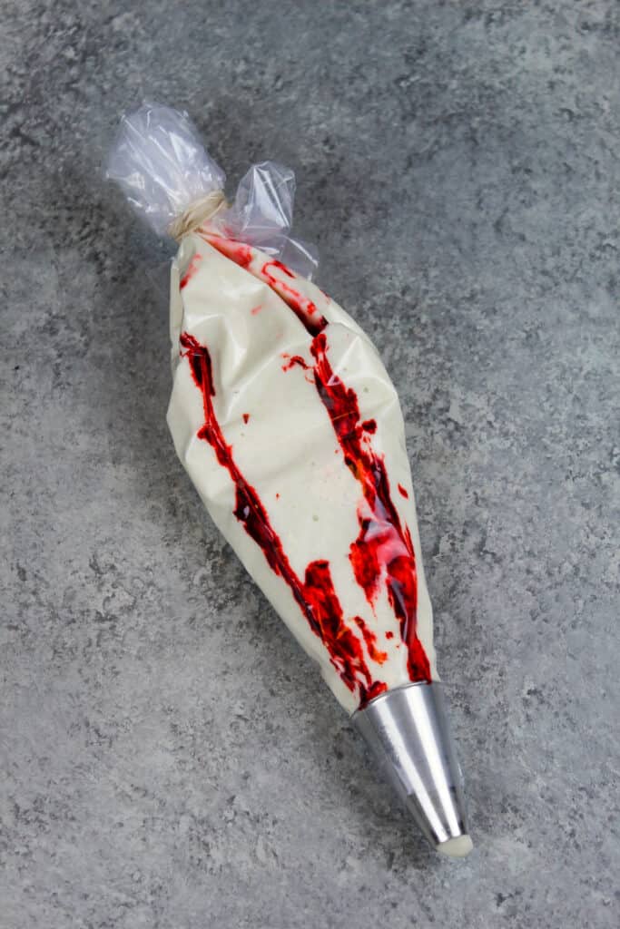 图像的法国未曾斜管袋的条纹与凝胶食用色素漂亮涡旋状的红色薄荷马卡龙