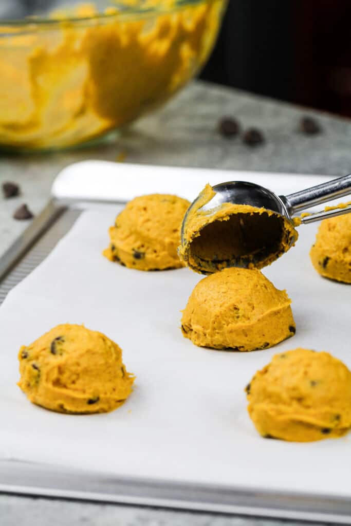 素食主义者巧克力芯片南瓜曲奇饼的图象被舀在一个被排行的烘烤板上与曲奇饼瓢