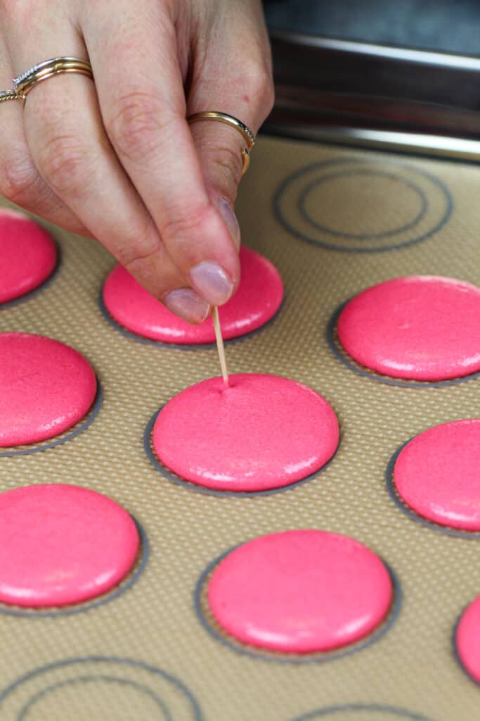 被用被用管道的桃红色macaron壳的图象，并且有他们的气泡突然用牙签