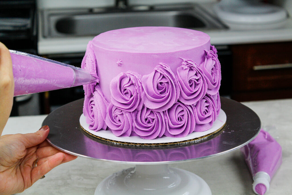 紫色乳酪玫瑰花的图像a在蛋糕周围用威尔顿1m霜尖