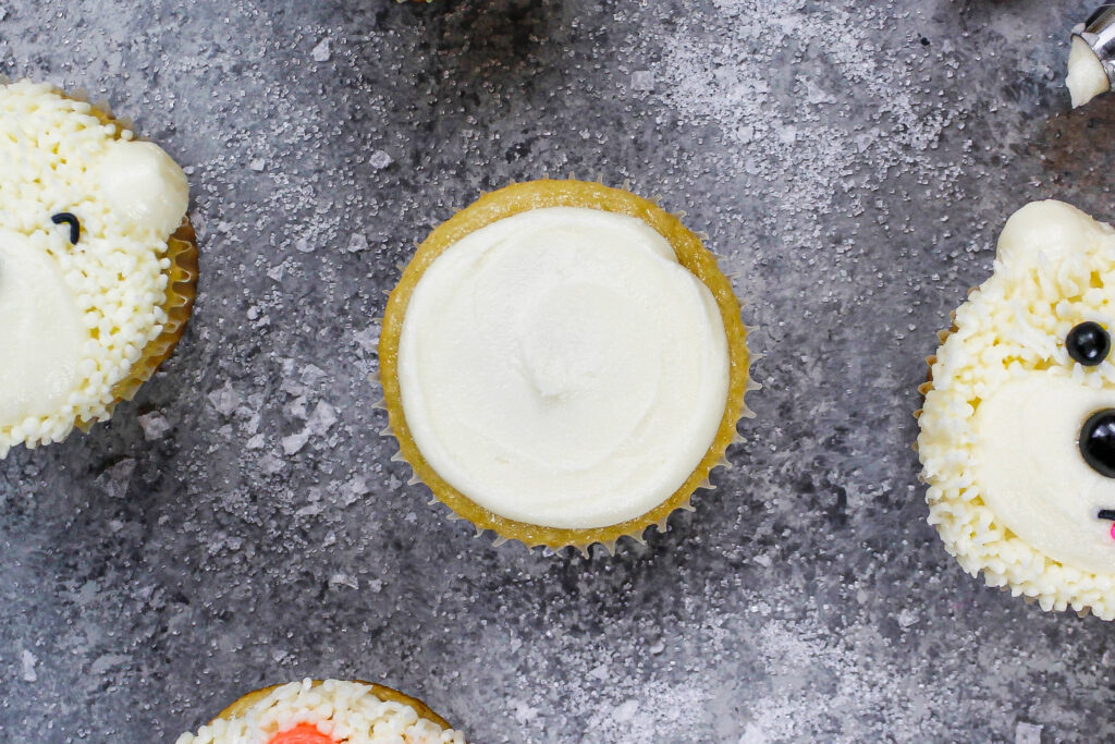 这是一个覆盖了一层薄薄的奶油的杯形蛋糕，做成了北极熊杯形蛋糕