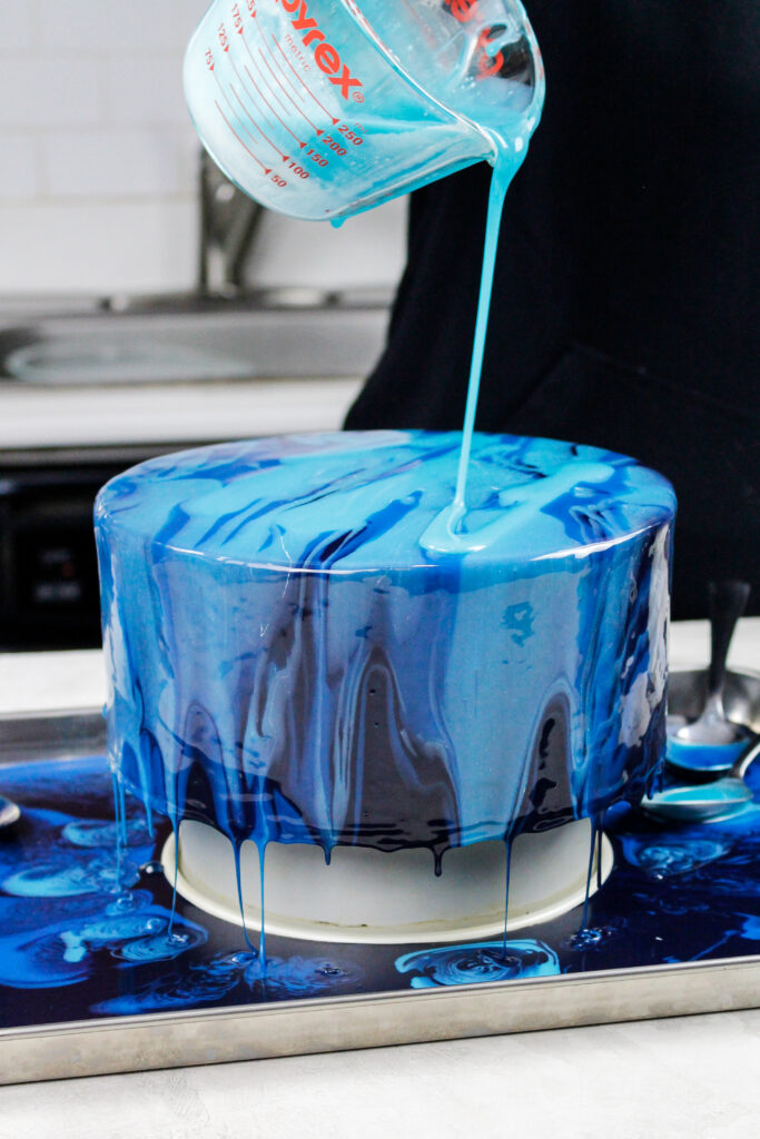 蓝色镜面釉被浇在冰冻的奶油蛋糕上