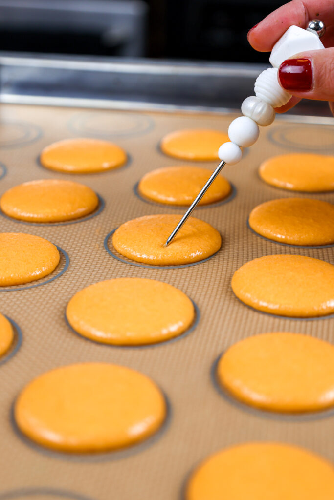 休息在柜台以后的橙色macaron壳的图象休息在柜台以后