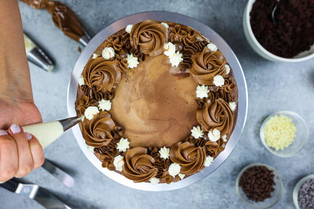 这是一个三层巧克力蛋糕，里面充满了牛奶巧克力、奶油和黑巧克力甘纳许