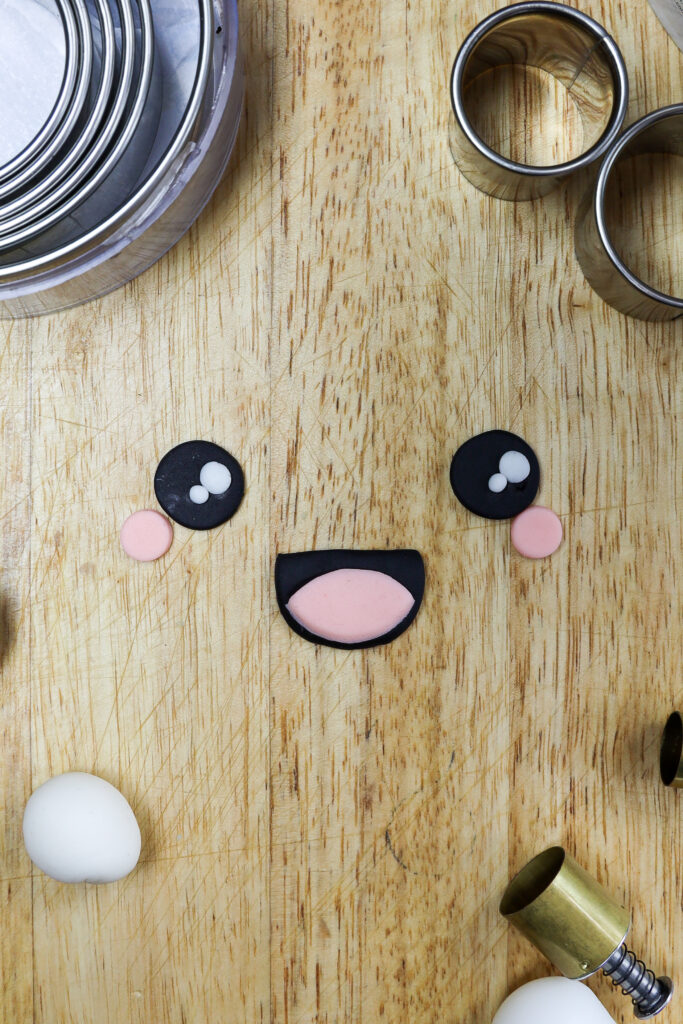 在独角鲸蛋糕上切成脸的方旦糖的图像