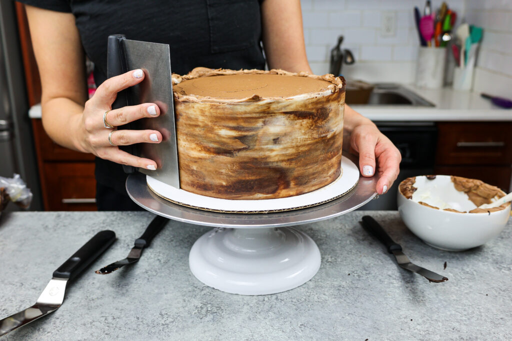 大理石状的巧克力奶油被平滑地抹在三层巧克力蛋糕上