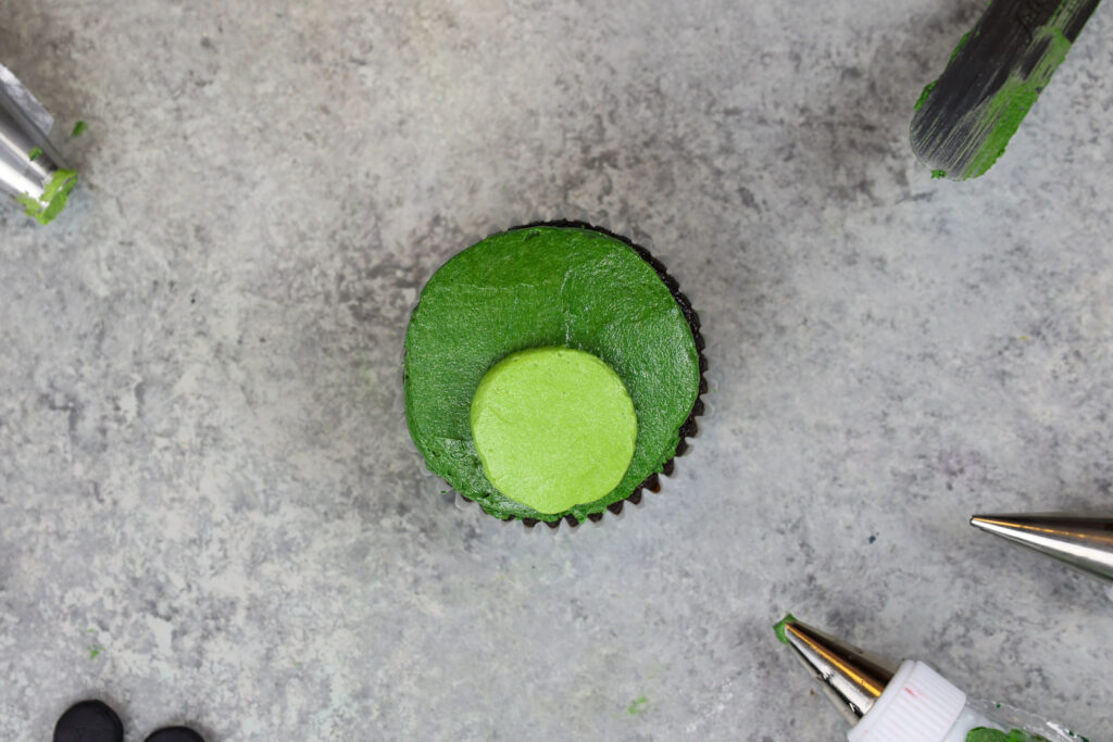 青蛙纸杯蛋糕被涂上奶油糖霜装饰