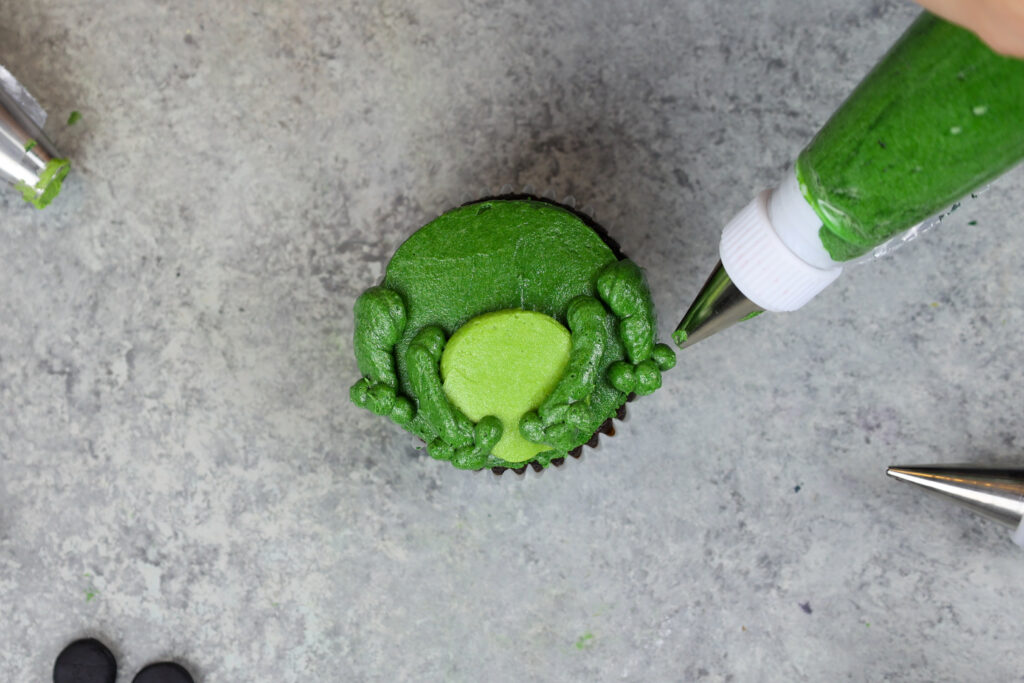 青蛙纸杯蛋糕被涂上奶油糖霜装饰