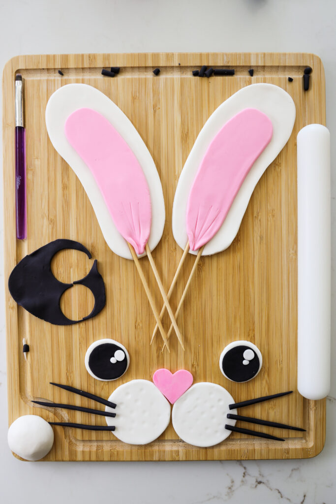 用方糖装饰兔子蛋糕的兔子脸和耳朵的图像