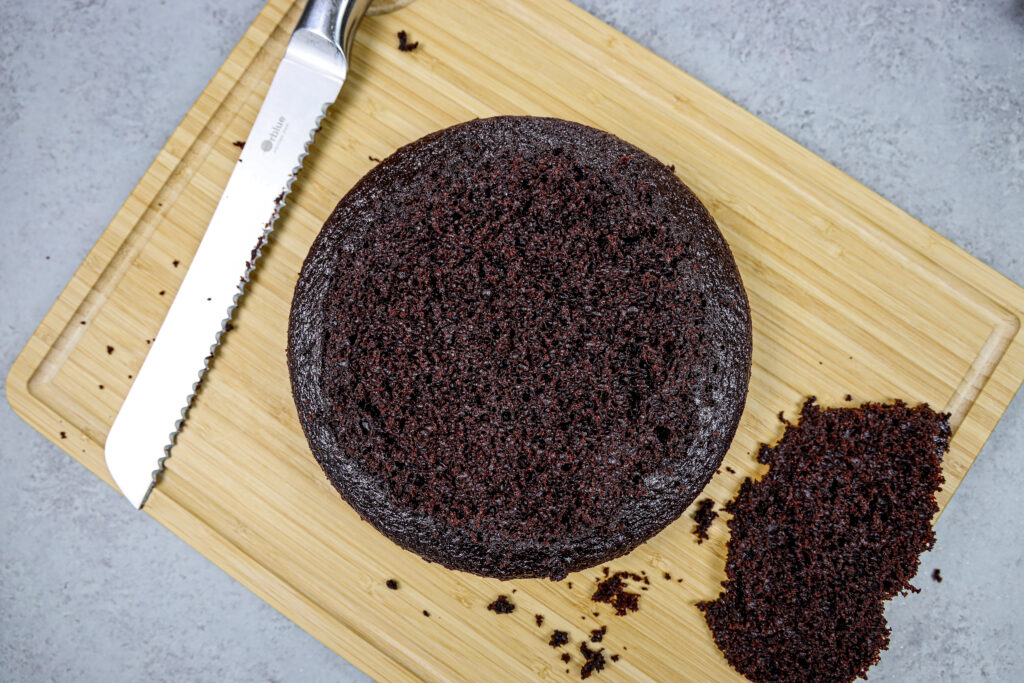 一层湿巧克力蛋糕层的形象，它被锯齿刀平整，使蛋糕更容易堆叠