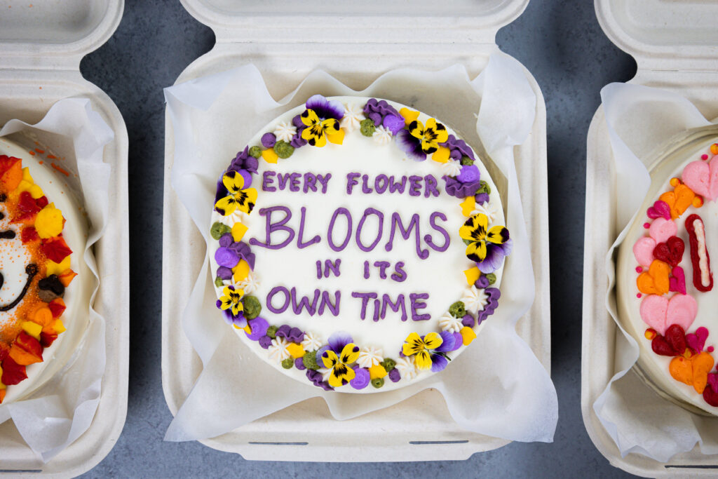 可爱的便当蛋糕或午餐盒蛋糕的图像，装饰有可爱的俗语和可食用的花朵