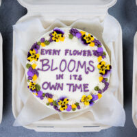 可爱的bento蛋糕或午餐盒蛋糕的图象装饰着可爱的谚语和可食的花