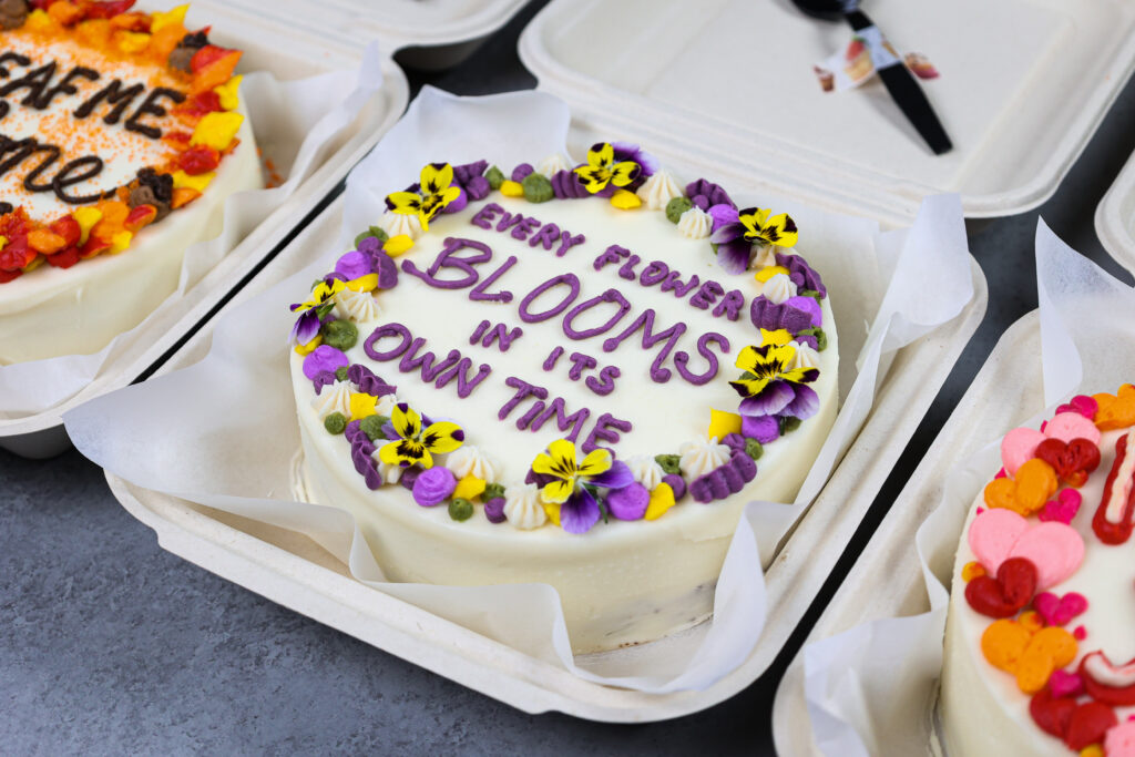 可爱的便当蛋糕或午餐盒蛋糕的图像，装饰有可爱的俗语和可食用的花朵