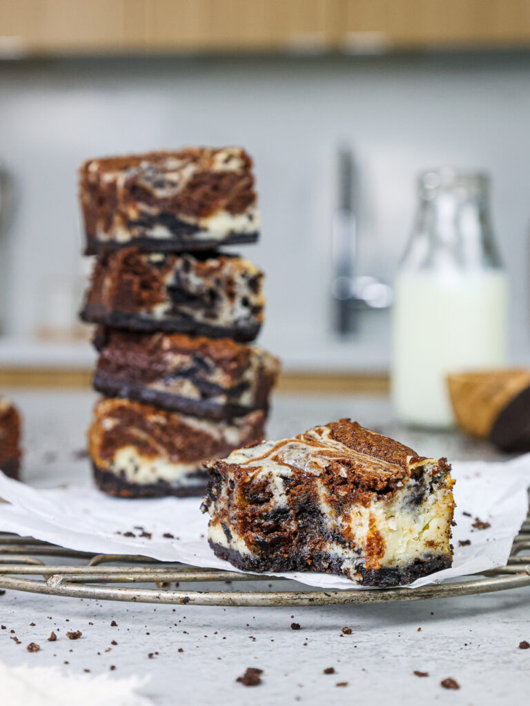 奥利奥芝士蛋糕布朗尼的图像被咬了，以显示其巧克力巧克力蛋糕和奥利奥芝士蛋糕的漩涡
