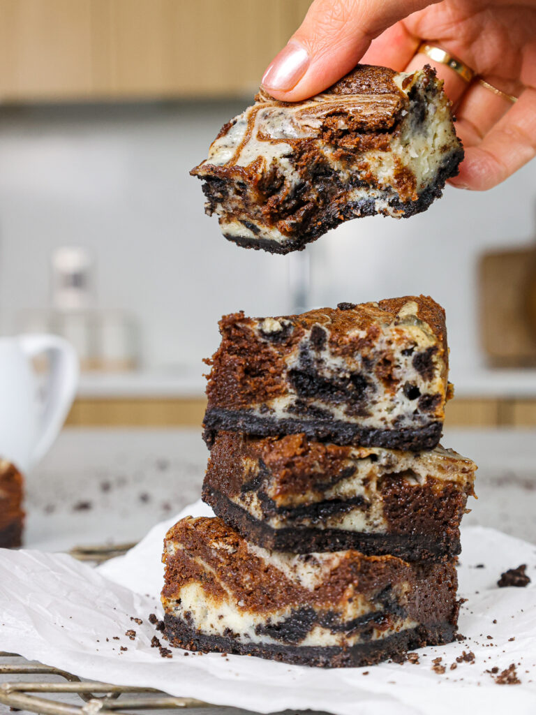 奥利奥芝士蛋糕布朗尼的图像被咬了，以显示其巧克力巧克力蛋糕和奥利奥芝士蛋糕的漩涡