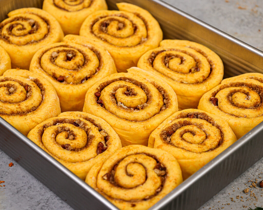 胡萝卜蛋糕肉桂卷的图像已在9 x 13英寸的锅中进行了证明，并准备烘烤