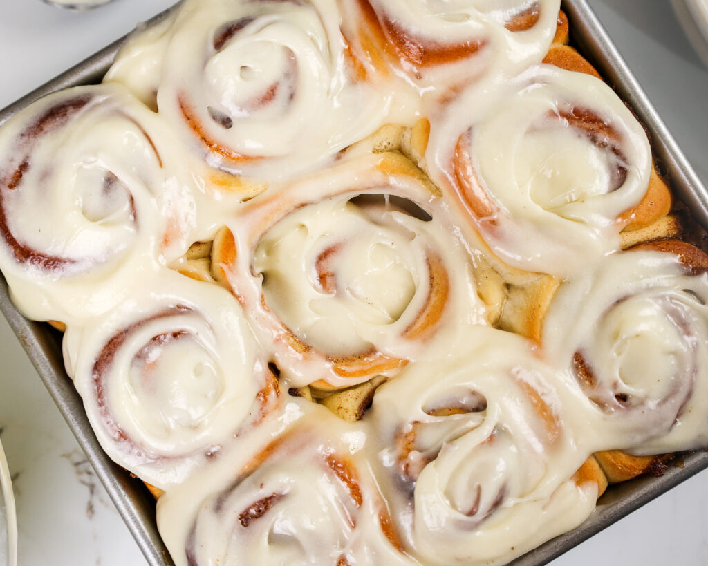 image of frosted quick yeast cinnamon rolls that have been slathered with cream cheese frosting