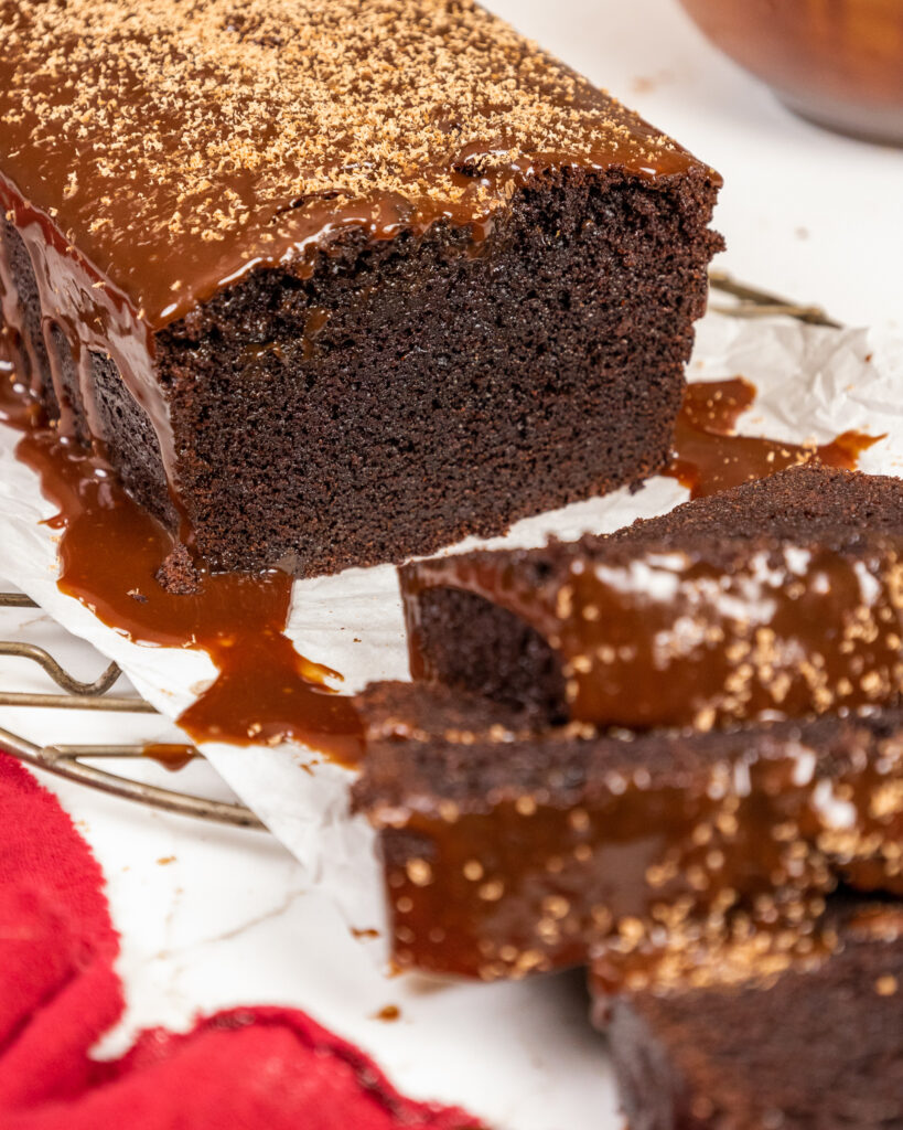 切成薄片的巧克力酸奶油奶油奶油蛋糕的图像，以显示它的柔软和湿润