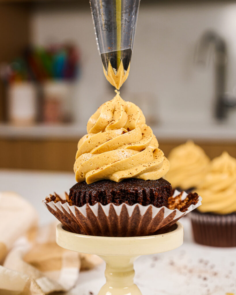 image of a cupcake being frosted with coffee buttercream frosting
