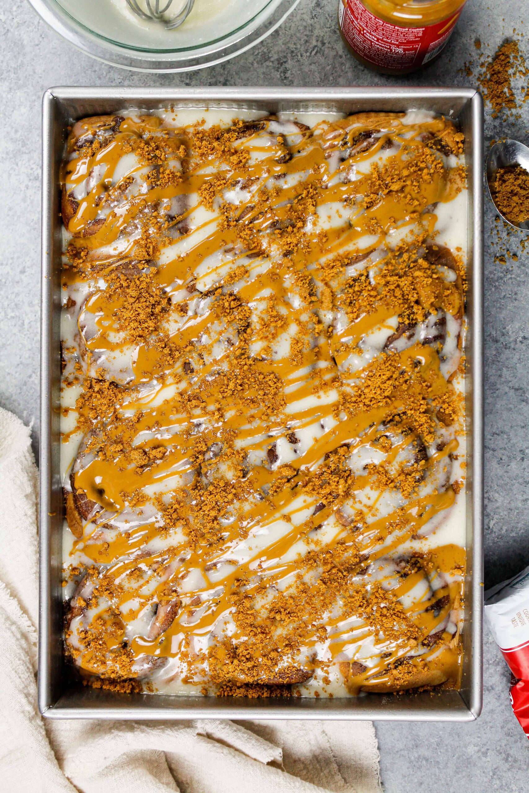 图像的biscoff肉桂卷烤锅,上面有融化的黄油饼干和碎biscoff饼干