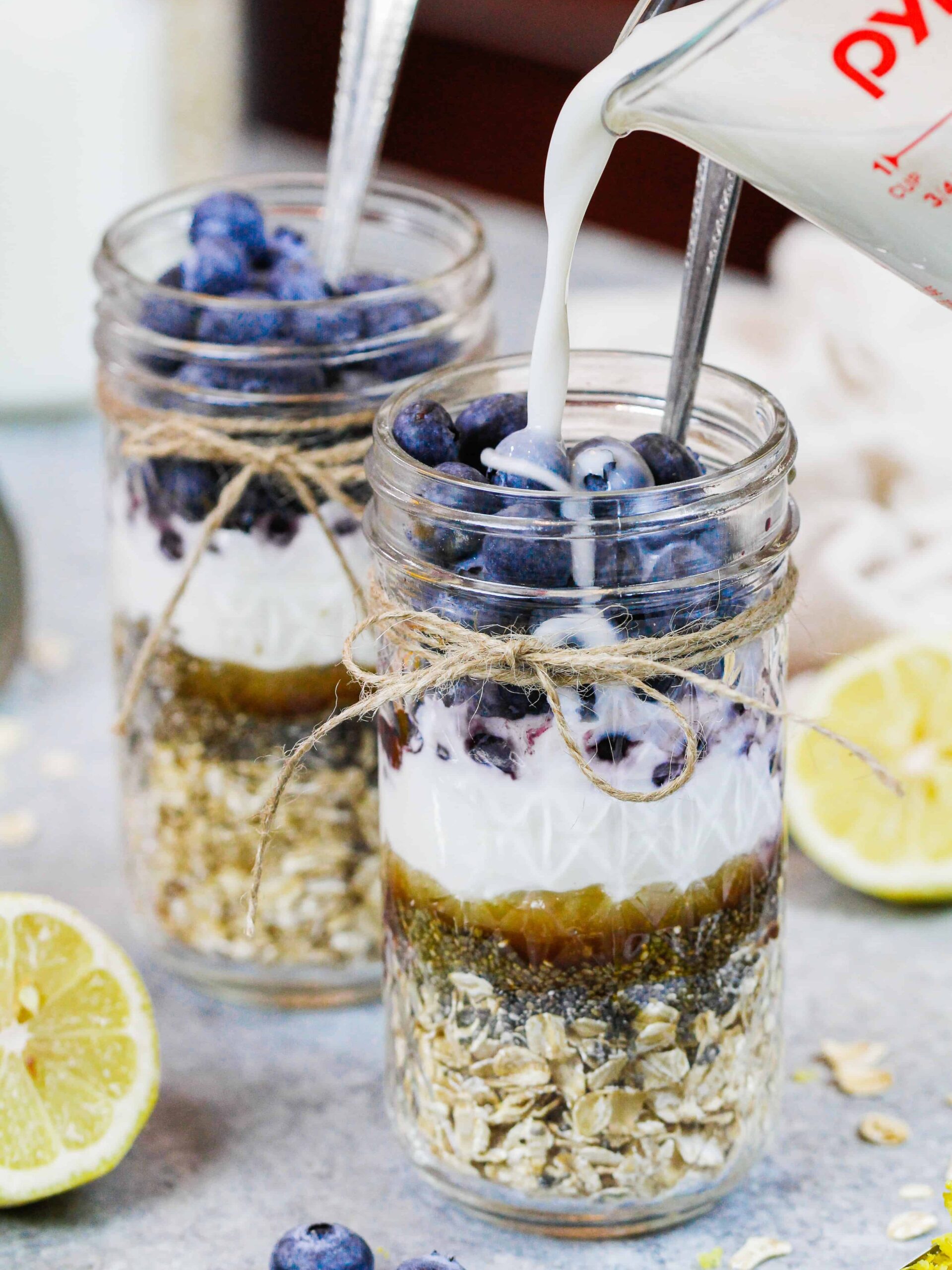 image of almond milk being poured into blueberry overnight oats