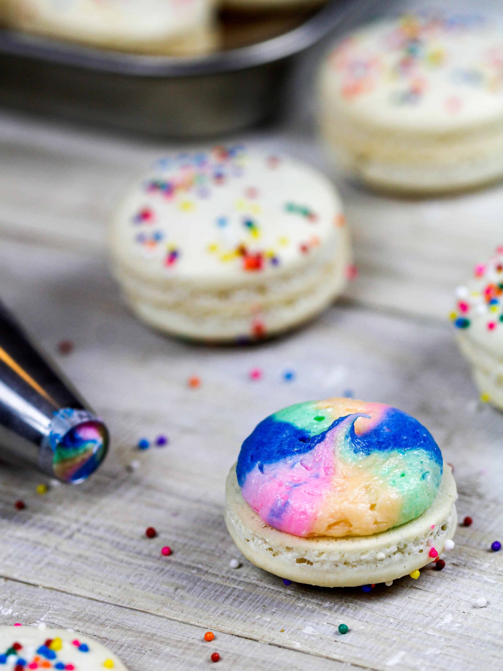 彩虹马卡龙带彩虹奶油的图像准备在上面放上第二个马卡龙外壳