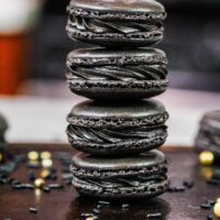 使用法国技术制作的黑马卡龙的图像，并充满黑色可可奶油