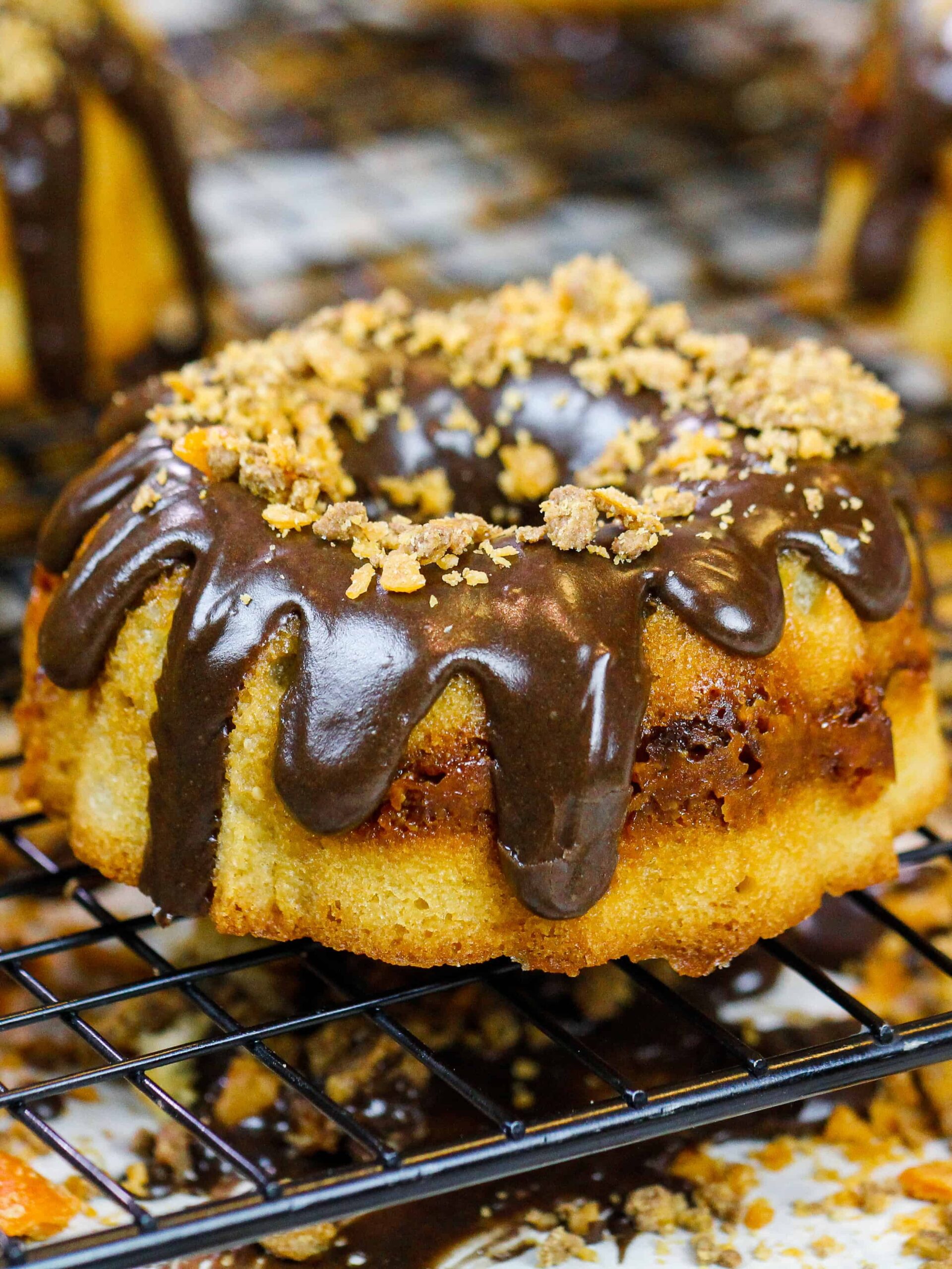 image of mini butterfinger bundt cakes topped with a chocolate peanut butter glaze