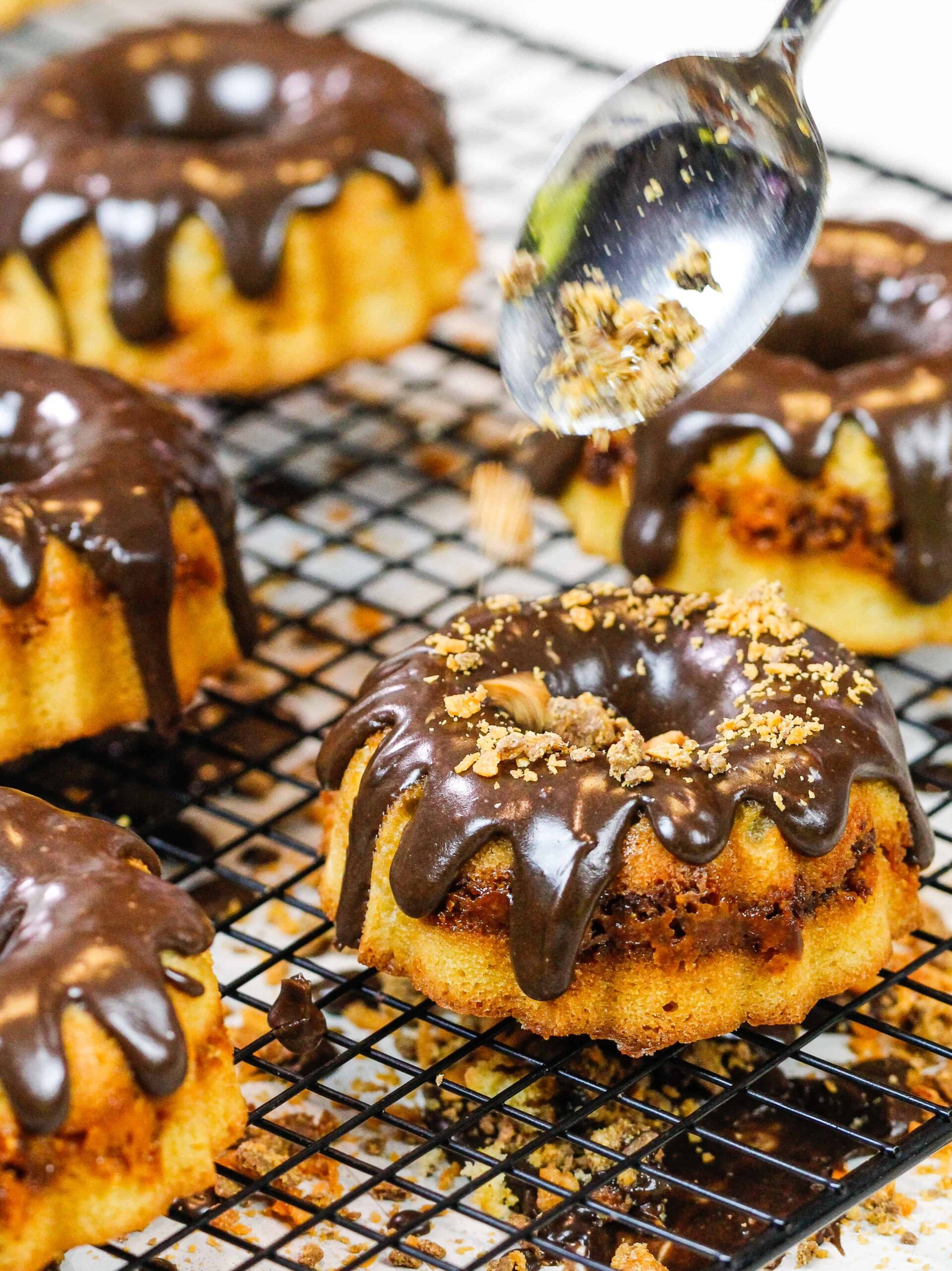 image of butterfinger bits being added to mini butterfinger bundt cakes