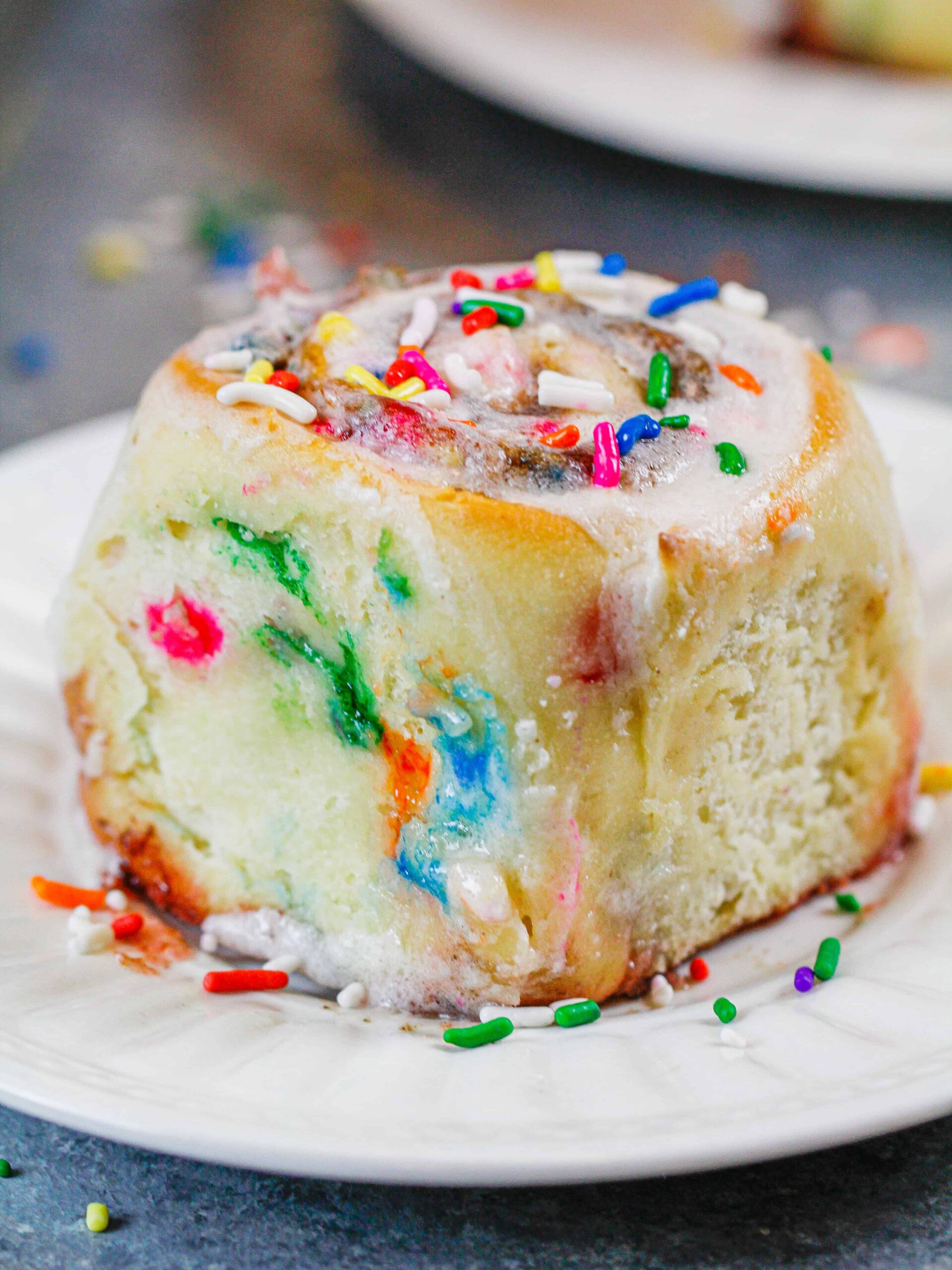 用洒水制成的Funfetti肉桂卷的图像，上面放上香草糖霜