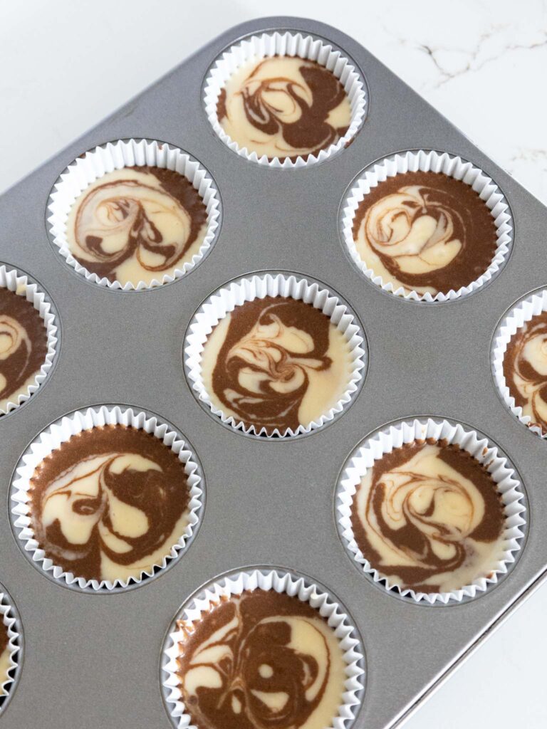 巧克力和香草纸杯蛋糕面糊的图像，它们已经旋转在一起制作大理石纸杯蛋糕